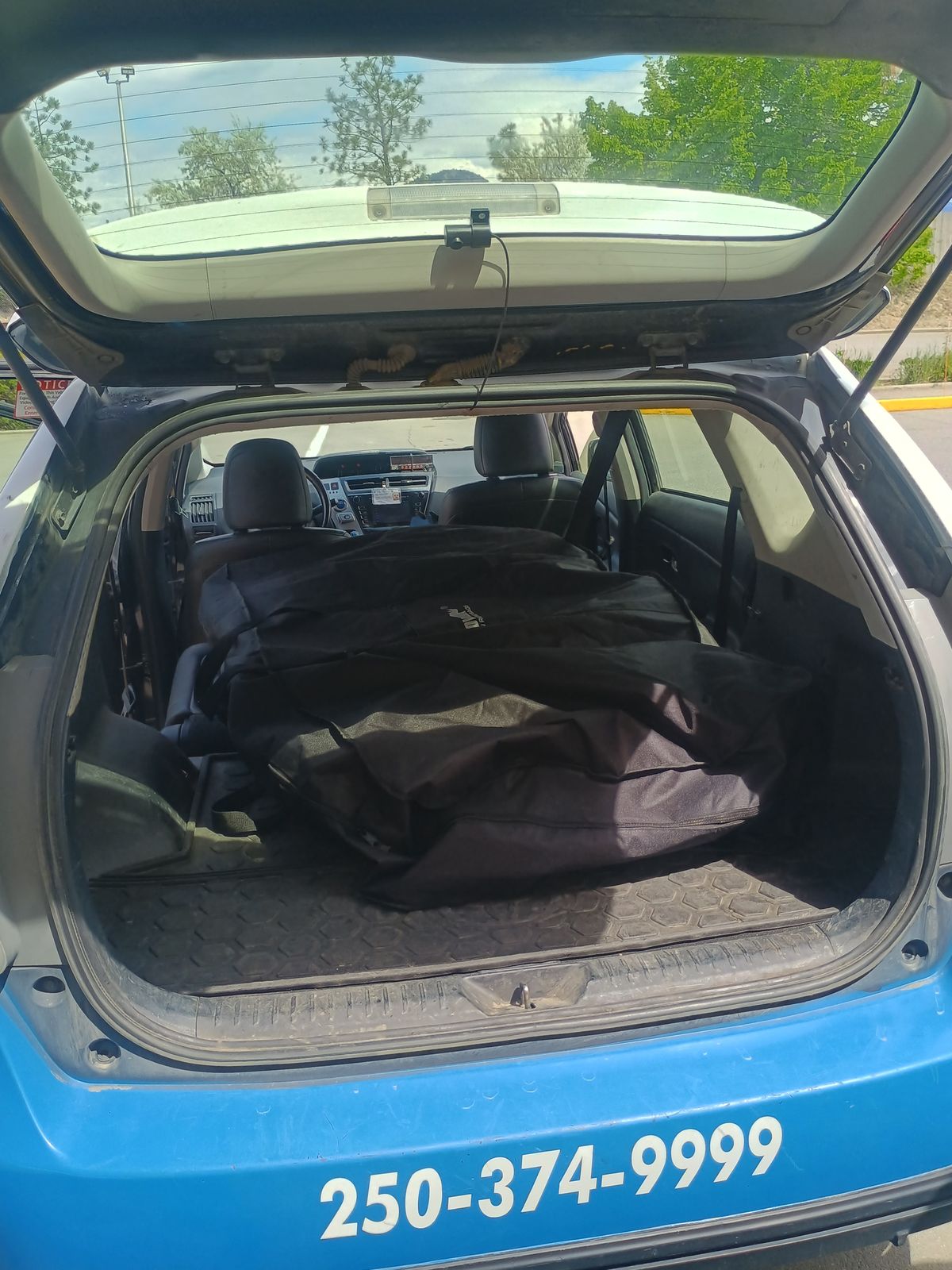 Bagged bike lying flat in the cargo area of a taxi