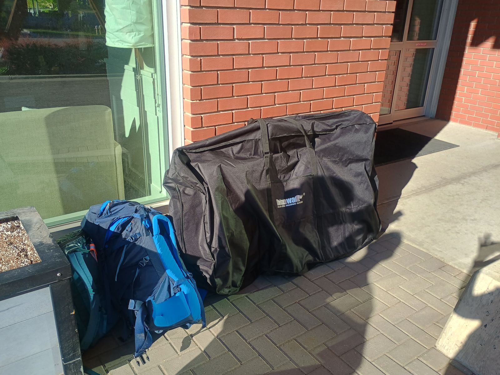 Packed bike bag and backpacks waiting outside a building